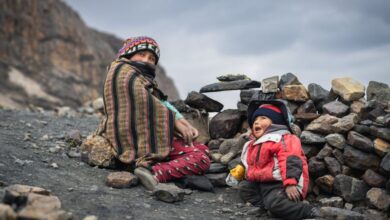 Family Locations - A mother and child sitting among rocks in the Andes, Huaraz, Peru.