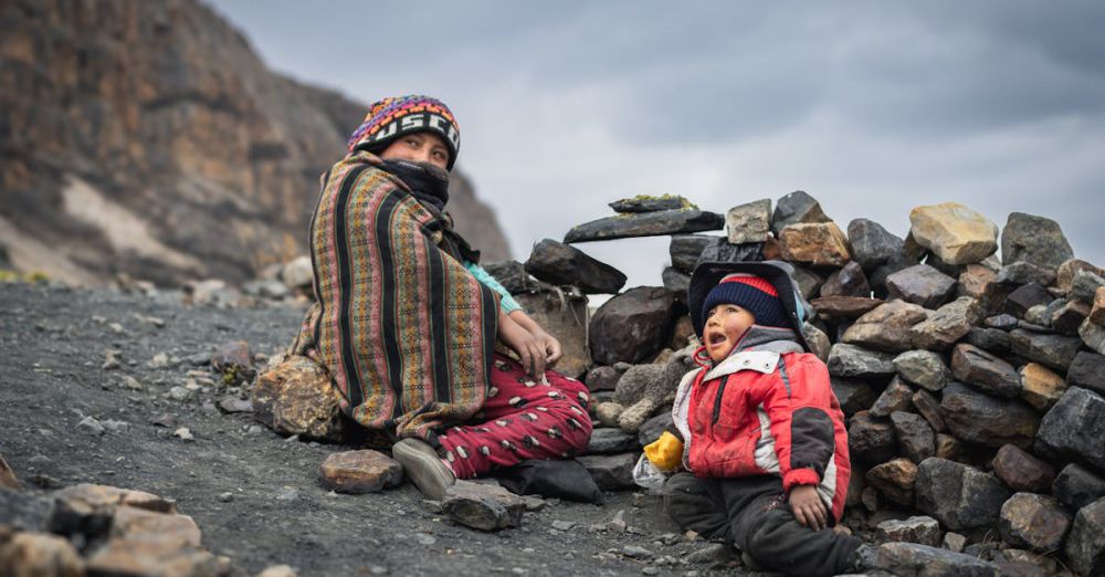 Family Locations - A mother and child sitting among rocks in the Andes, Huaraz, Peru.