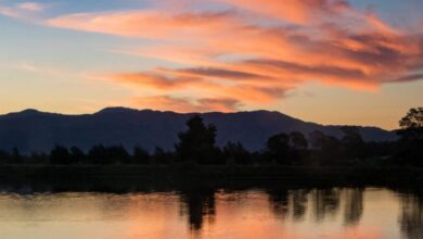 Canoeing Mistakes - A lone canoeist paddles peacefully on a serene lake during a vibrant sunset.