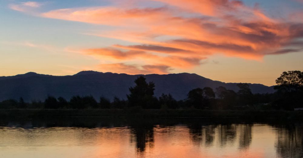 Canoeing Mistakes - A lone canoeist paddles peacefully on a serene lake during a vibrant sunset.