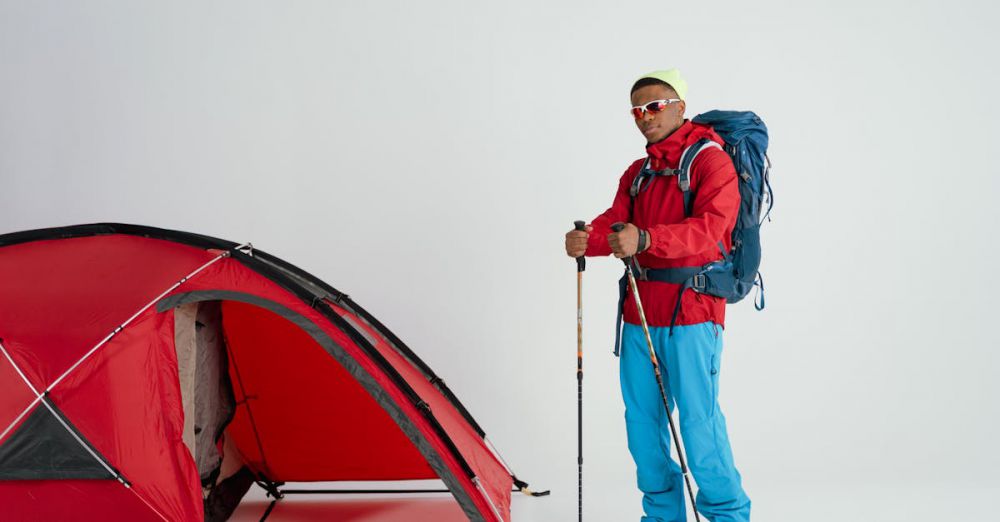 Snowshoeing Gear - Young man ready for a winter camping adventure with a tent and hiking gear.