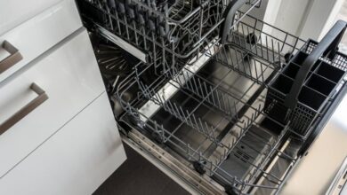 Dishwasher - A clean and empty stainless steel dishwasher open in a modern kitchen setting.