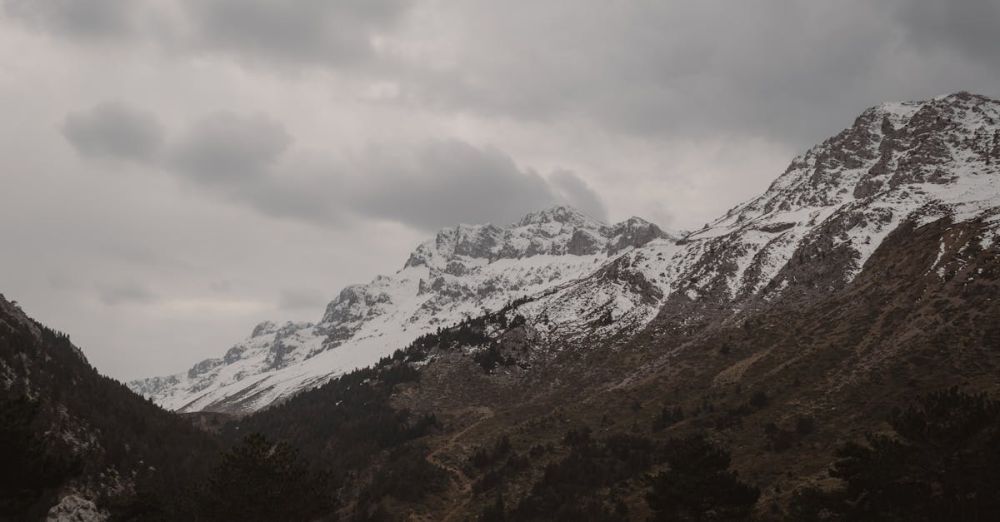 Hidden Trails - Serene view of snow-capped Taurus Mountains in Seydişehir under cloudy skies.