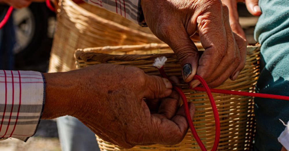 Snowshoeing Mastery - Detailed image of hands weaving a basket with red rope outdoors, showcasing traditional craftsmanship.