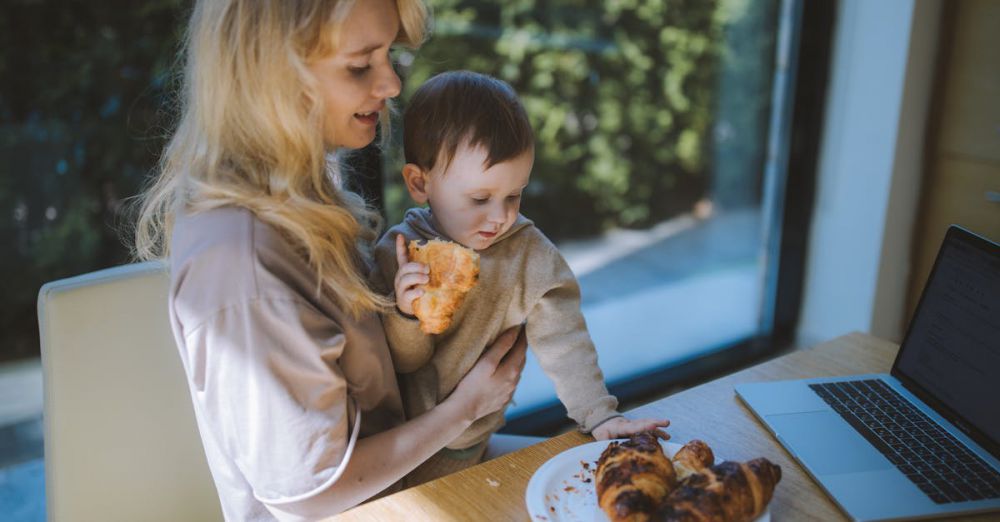 Snowshoeing With Kids - A mother and child share a joyful breakfast with croissants, embodying family togetherness at home.