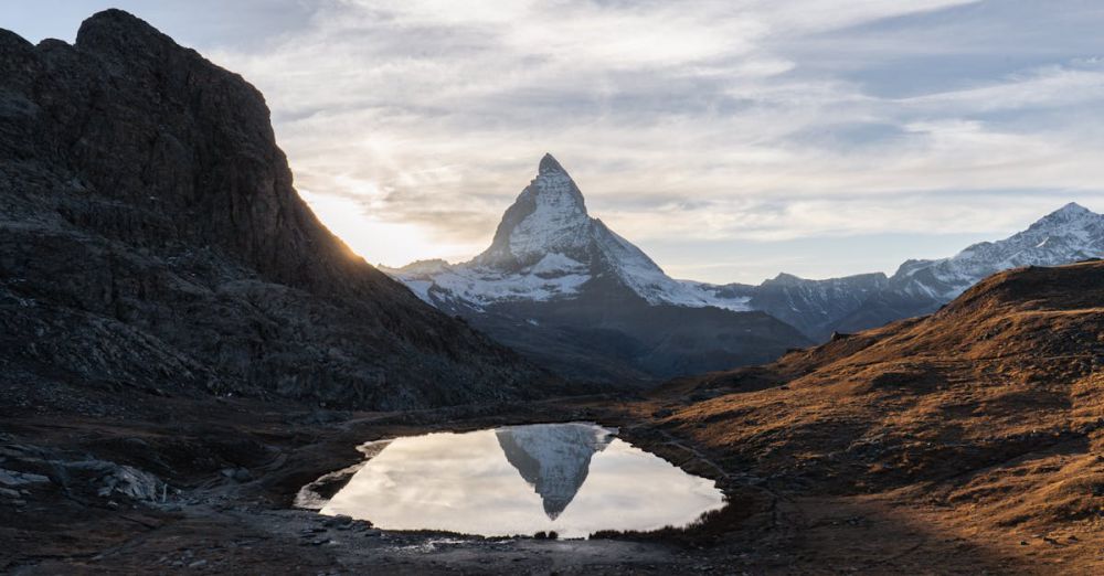 Adventure Trails - Sunset over the Matterhorn's reflection in an alpine lake near Zermatt, Switzerland.