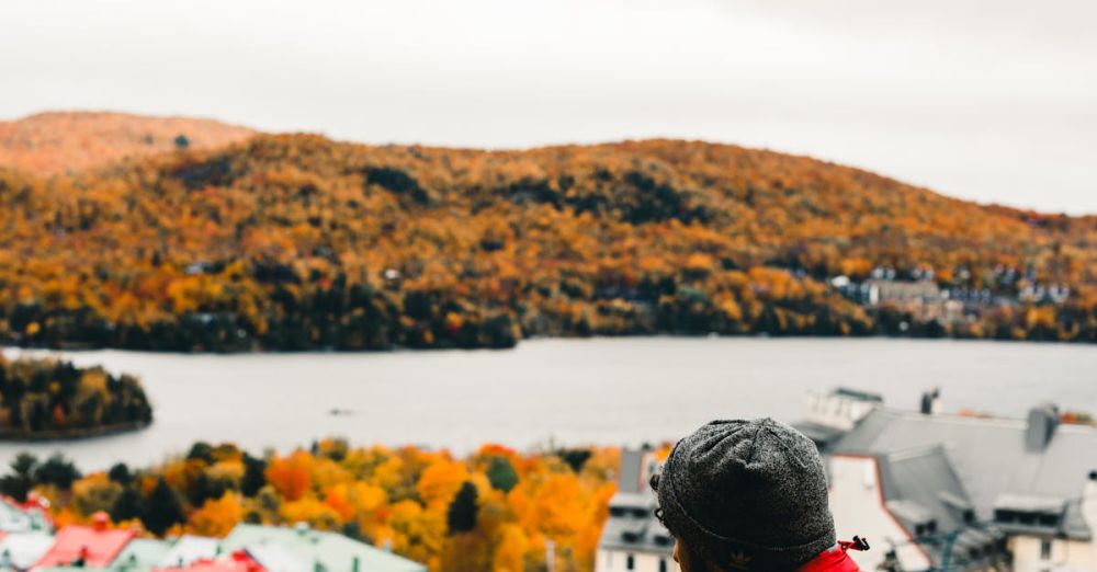 Quebec Trails - Person in red jacket enjoying fall view in Mont-Tremblant, Canada with a warm beverage.