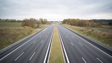 Peaceful Routes - A serene image of an empty highway stretching through a peaceful countryside under a cloudy sky.