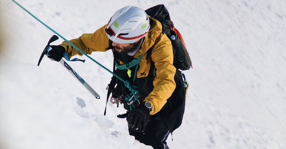 Ice Climbing Safety - A climber tackles a snowy incline using an ice axe on a sunny winter day.