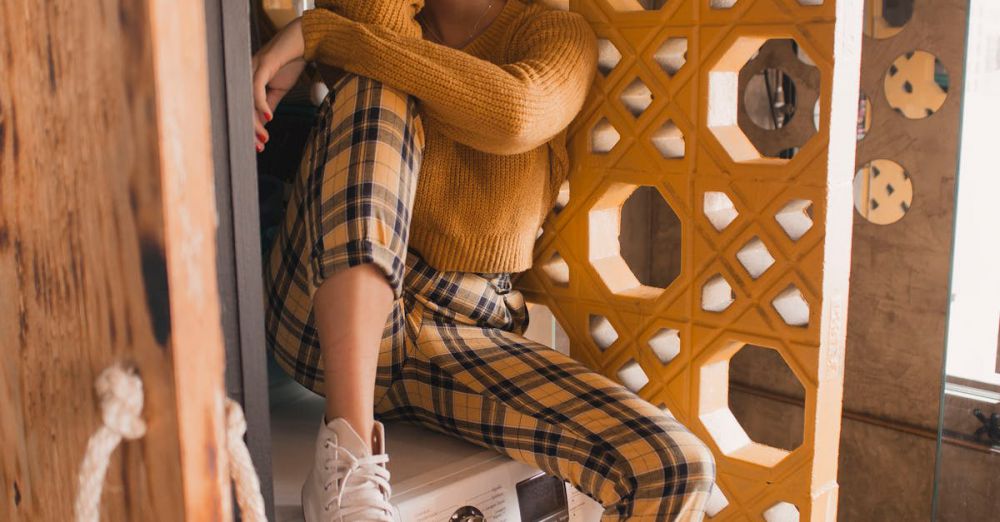 Washer - Trendy woman sitting on a washing machine in a modern, artistic laundry room setting.