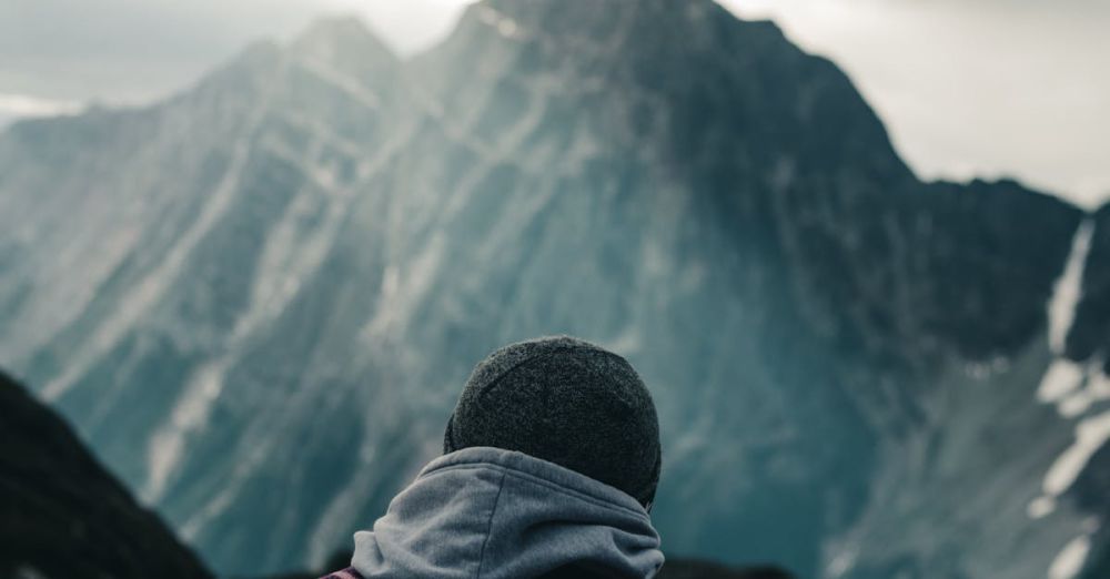 BC Climbing - Person in warm attire gazing at stunning mountain view in British Columbia, Canada.