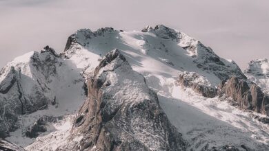 Year-Round Ice Climbing - A breathtaking view of a snow-capped mountain range under a clear sky, capturing winter's beauty.