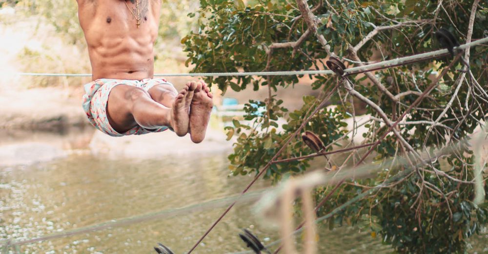 Climbing Mistakes - A man enjoying an outdoor adventure, swinging on a tree above a river.