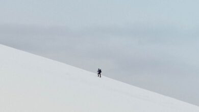 Extreme Cold Climbing - A lone hiker ascends a snowy slope in Norway's remote wilderness, showcasing winter adventure.