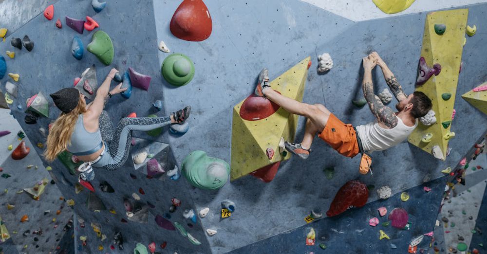 Challenging Routes - Two active climbers tackle a challenging indoor rock climbing wall, showcasing skill and athleticism.