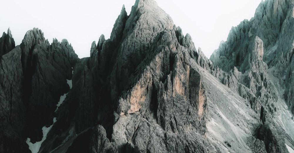 Remote Ice Climbing - Stunning day view of the jagged Dolomites mountain peaks with snow patches.