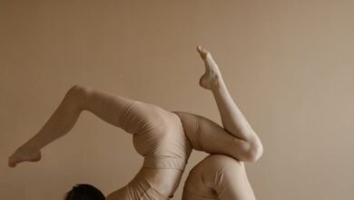 Beginner Tours - Two women performing an acrobatic pose indoors showcasing flexibility and balance.