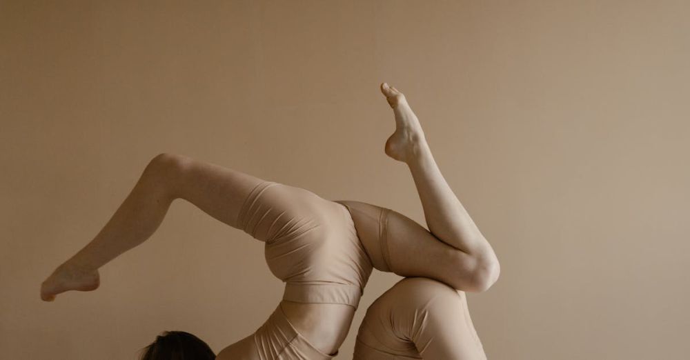 Beginner Tours - Two women performing an acrobatic pose indoors showcasing flexibility and balance.