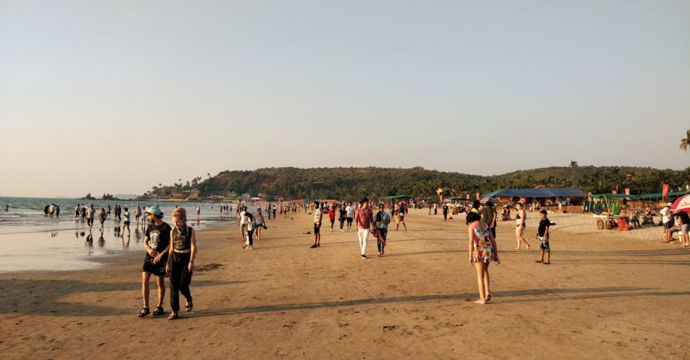 Family Tours - A lively beach scene with people enjoying the sandy shore and vibrant atmosphere during sunset.