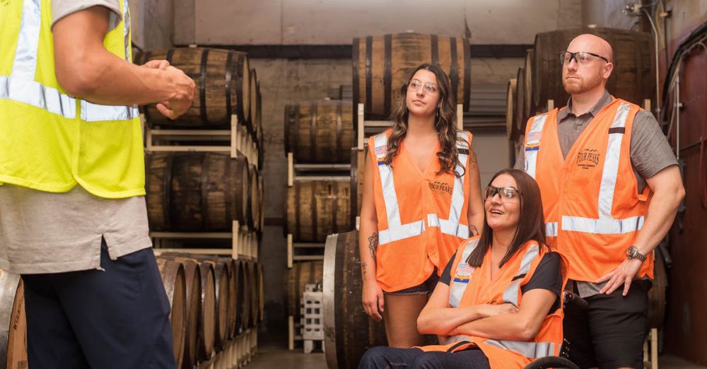 Tour Safety - Group of adults in safety vests touring a brewery, highlighting inclusivity and accessibility.