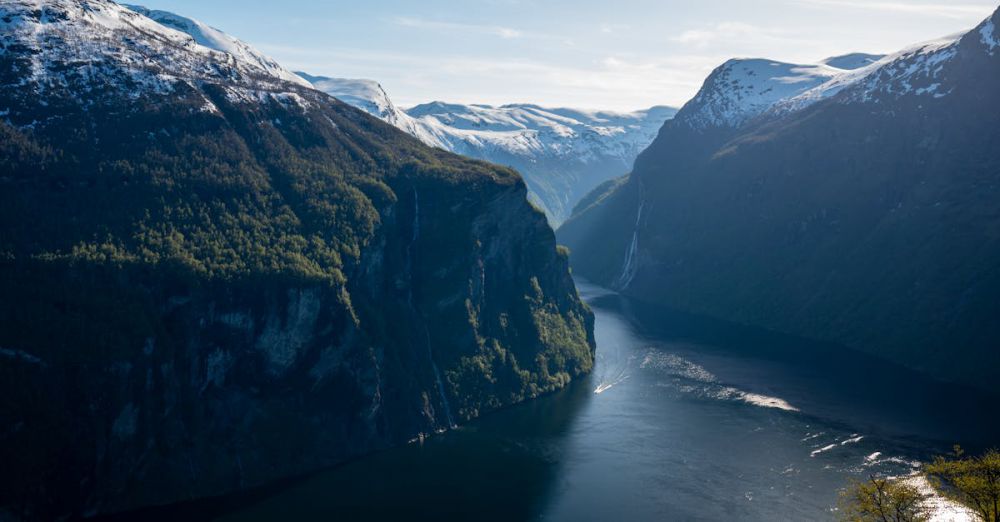 Year-Round Glacier Tours - Scenic view of snow-capped mountains and deep blue fjord in Geiranger, Norway.