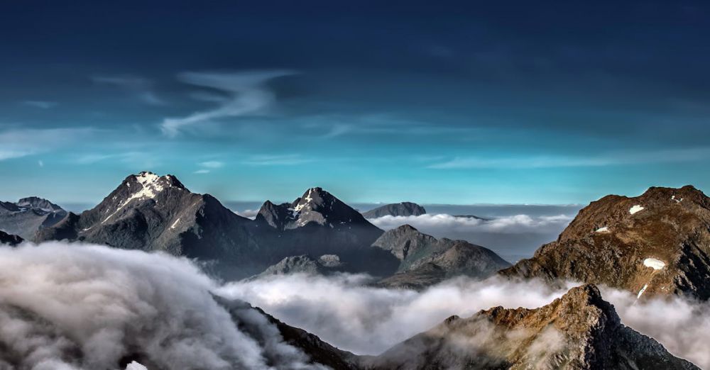 Glacier Experiences - A stunning view of snow-capped mountains in the Lofoten Archipelago surrounded by clouds.