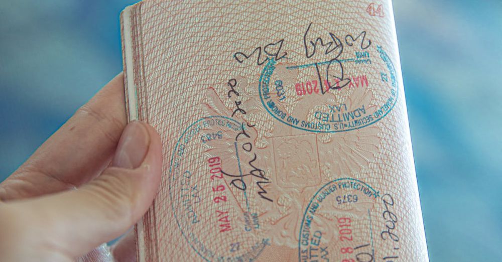 Tour Booking - A close-up view of a hand holding an open passport with various stamps, highlighting travel experiences.