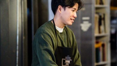 Fridges - Asian man in a photo lab developing film, wearing apron and smiling.