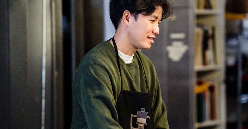 Fridges - Asian man in a photo lab developing film, wearing apron and smiling.