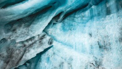 Unique Glacier Tours - A detailed aerial view showcasing intricate glacier patterns and melting ice with vivid blue tones.