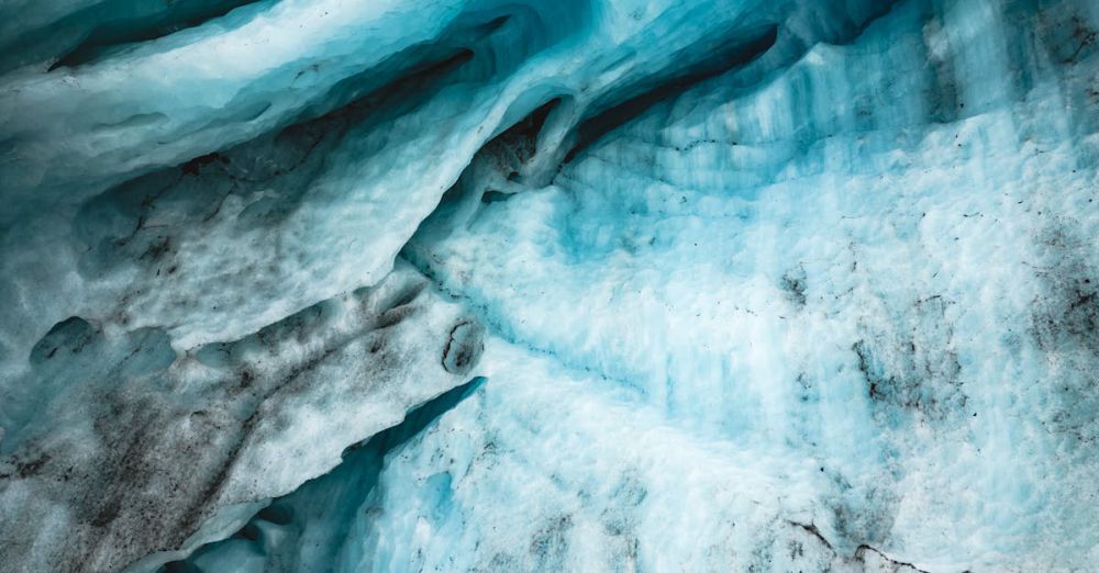 Unique Glacier Tours - A detailed aerial view showcasing intricate glacier patterns and melting ice with vivid blue tones.