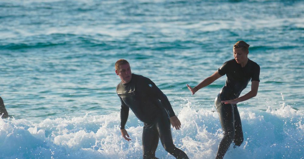 Advanced Surfers - Two surfers enjoying a sunny day riding waves at the ocean shore.