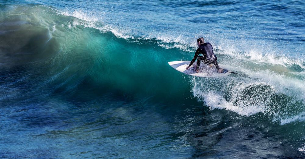 Surfing Skills - A thrilling capture of a surfer skillfully riding a wave in the open ocean, showcasing the excitement of surfing.