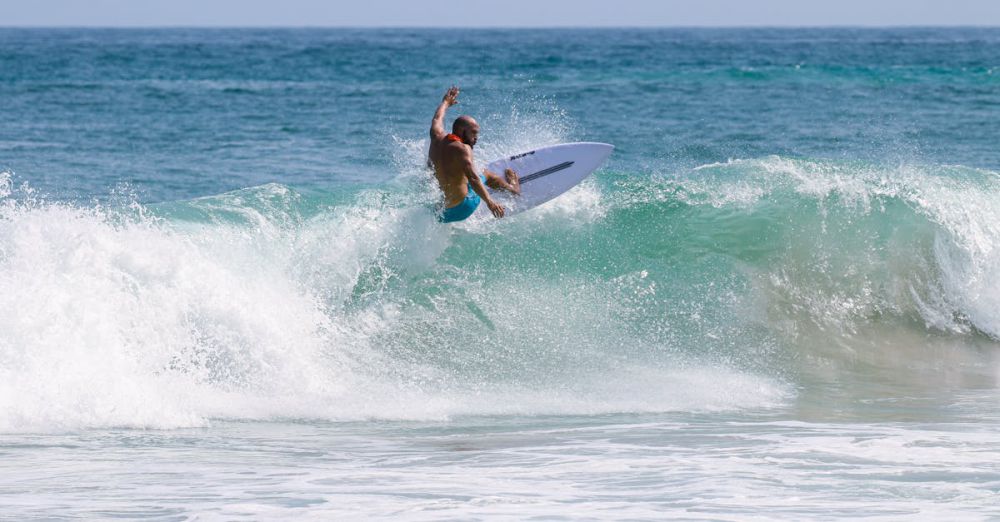 Surfing Photography - A person riding a surfboard on top of a wave