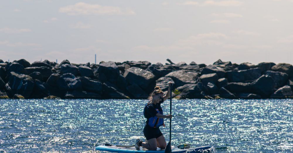 Ontario Surfing - A person enjoying stand up paddleboarding on Lake Ontario in Toronto under a blue sky.