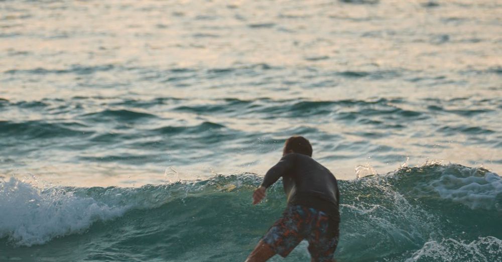 Sunset Surfing - A surfer skillfully rides a wave during sunset, showcasing the thrill of ocean adventure.