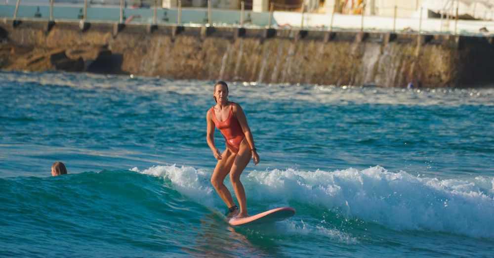 Surfing Mistakes - Woman surfing on a wave by the shore with buildings in the background, enjoying a sunny day.