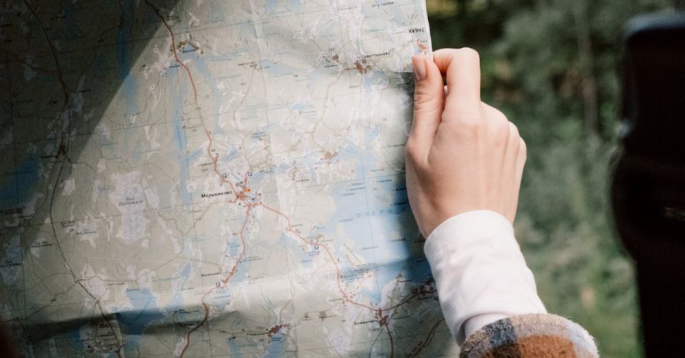 Road Trip Routes - A person holding a map inside a car, ready for a journey.