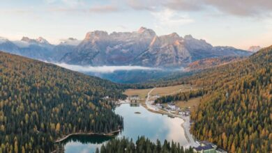 Photography Tours - Breathtaking aerial view of a tranquil lake surrounded by mountains in autumn, perfect for travel and nature enthusiasts.