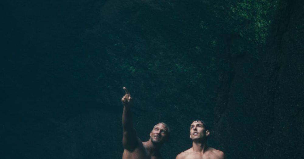 Hidden Spots - Two topless men standing in a cave in Bali, showcasing adventure and exploration.