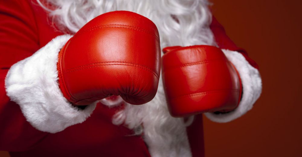 Fitness Gifts - Santa Claus wearing red boxing gloves, ready for the holiday season. Close-up of costume and gloves.