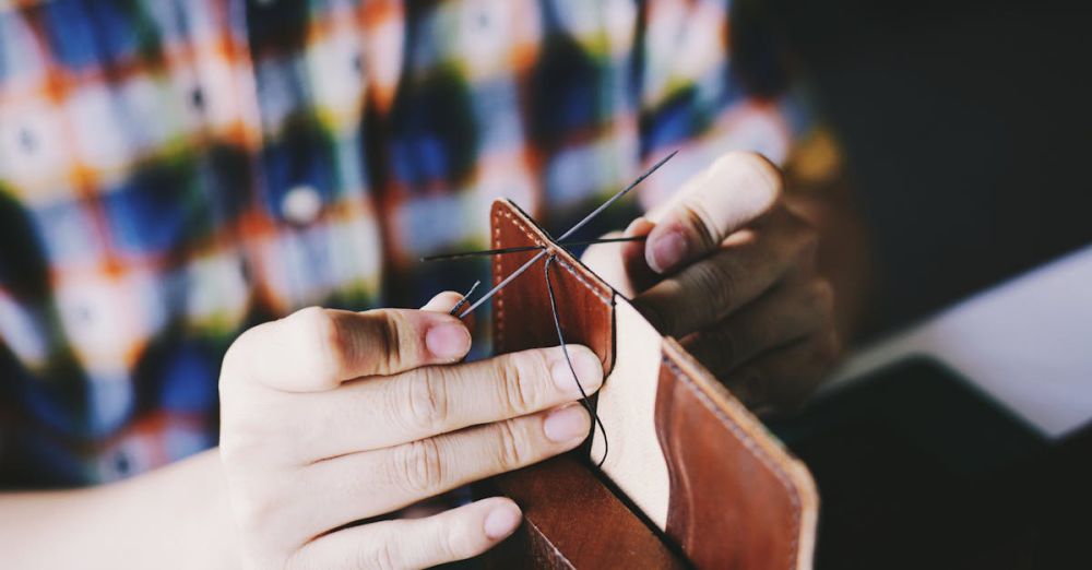 Leather Wallet - Close-up of a person hand-stitching leather, showcasing detailed craftsmanship and DIY skills.