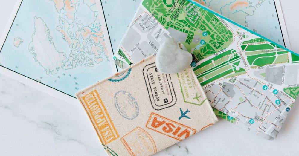 Tour Preparation - An overhead view of a passport holder on top of maps, symbolizing travel and exploration.