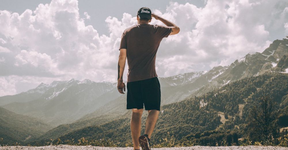 Solo Climbers - A man enjoys mountain hiking with stunning views of peaks and clouds.