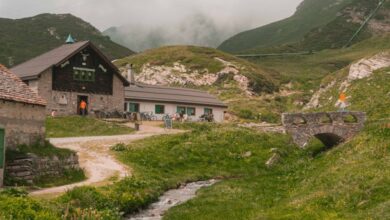 Scenic Trails - Tranquil mountain landscape with rustic cabins and lush greenery in Piemonte, Italy.