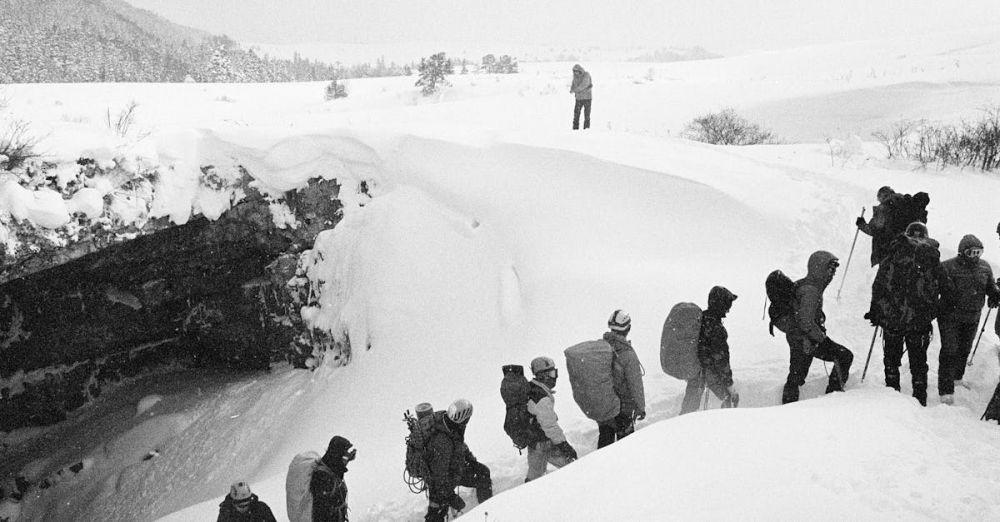 Climbing Conditions - A group of mountaineers braving harsh winter conditions in a snowy landscape, showcasing adventure.