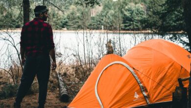 Ontario Trails - A man enjoying a camping trip with a tent by a lake in Algonquin Park, Canada.