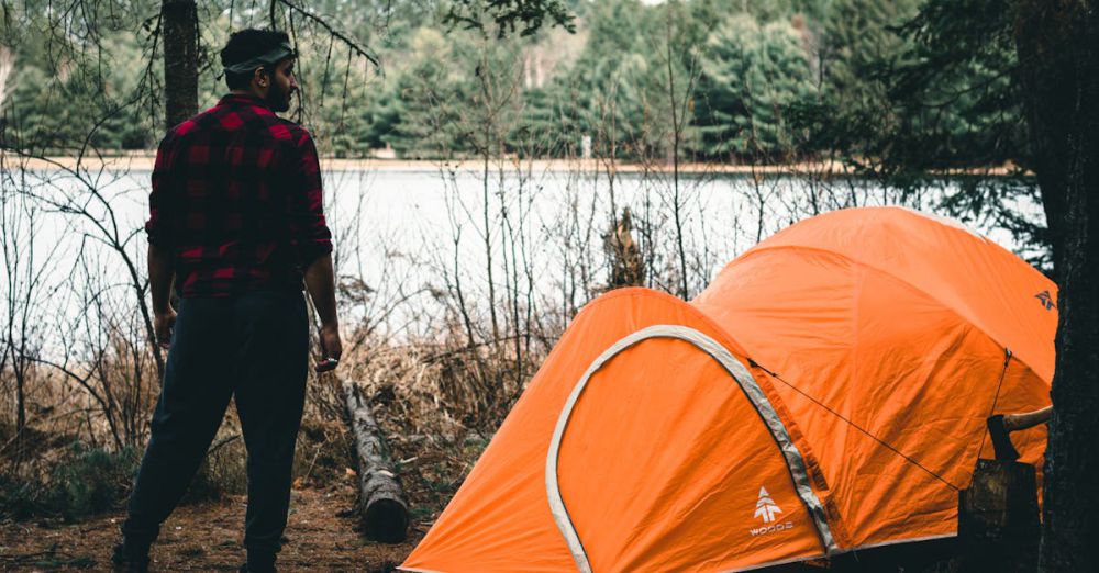 Ontario Trails - A man enjoying a camping trip with a tent by a lake in Algonquin Park, Canada.