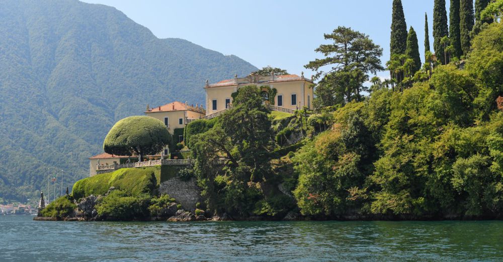 Popular Gardens - Picturesque villa surrounded by lush greenery on Lake Como, Italy, under a clear blue sky.