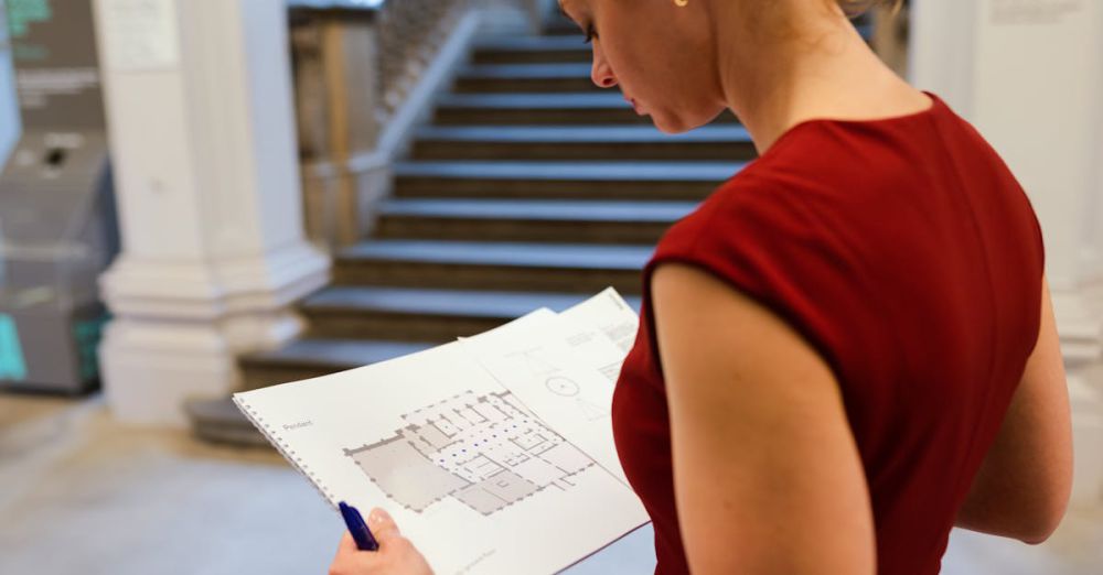 Museum Visit Planning - A professional woman examines an architectural floor plan in an indoor setting.